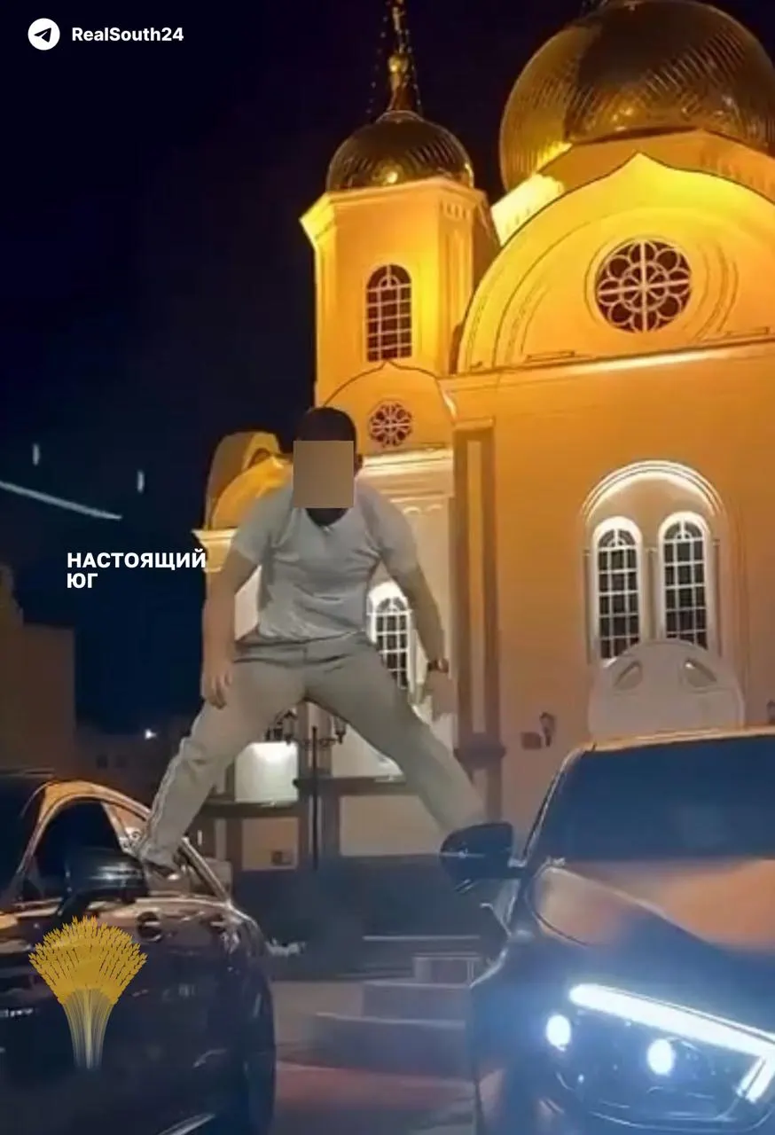 В Краснодаре полицейские задержали двух молодых людей после появления в сети ролика, где один из них стоит ногами на дверях припаркованных машин на фоне храма. Задержанные записали видео с публичными извинениями; вопрос о дальнейшем правовом статусе инцидента остаётся открытым.
